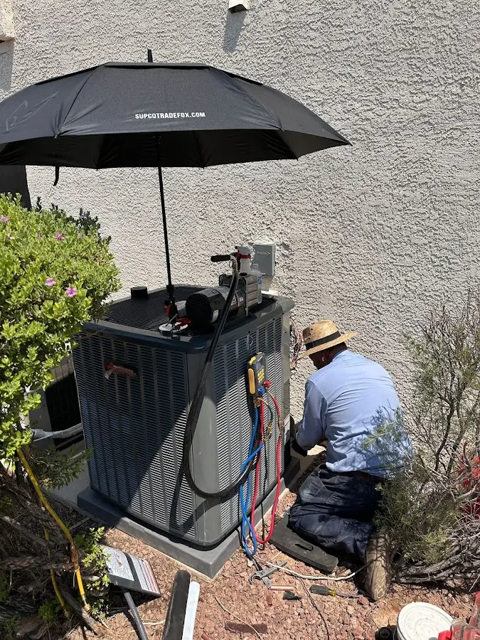 HVAC technician performing outdoor AC maintenance in Williams