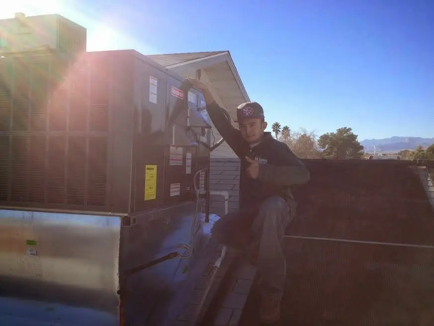 HVAC technician performing Boiler Repair on a rooftop unit in Williams